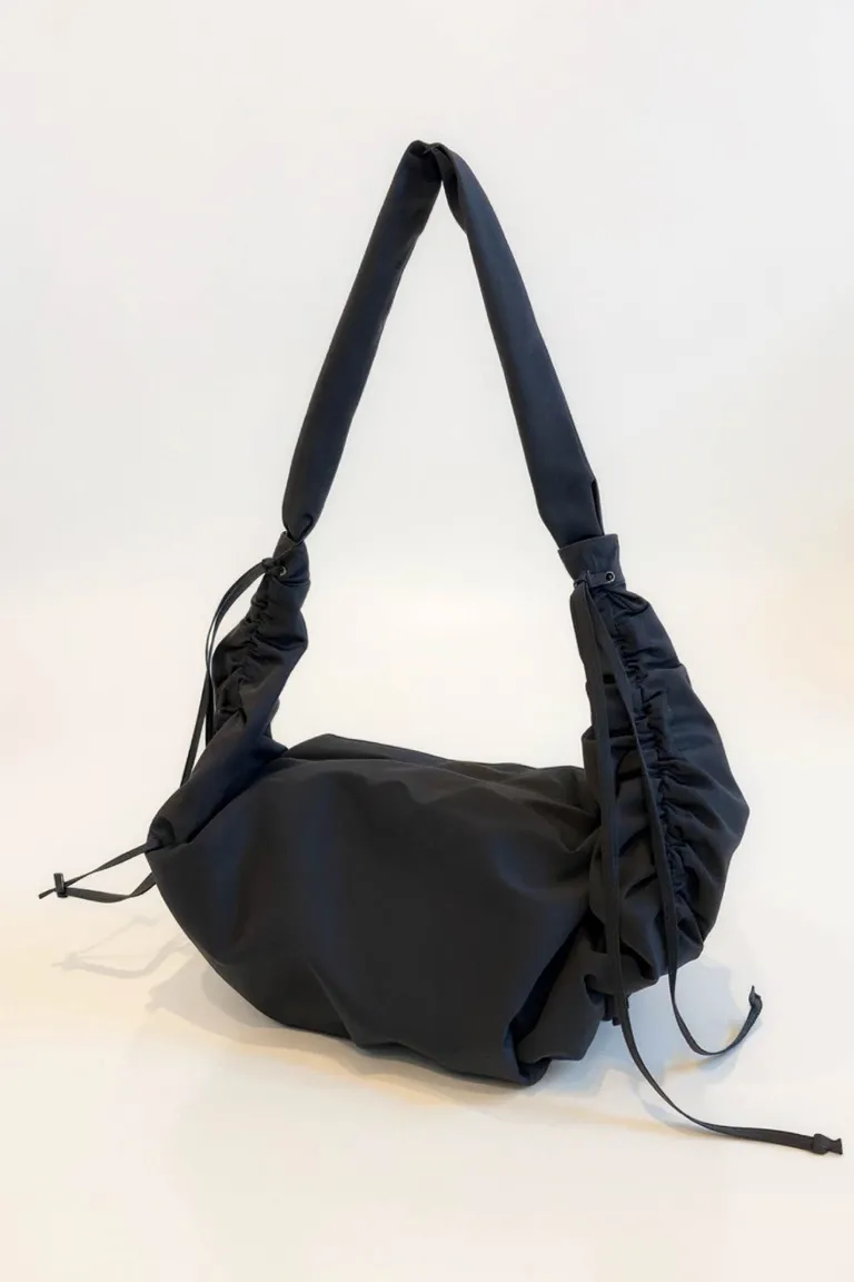 Cartera tipo hobo con detalle de frunces laterales y correa integrada de diseño contemporáneo de Maria Cher en Bolsos y Carteras para argentina