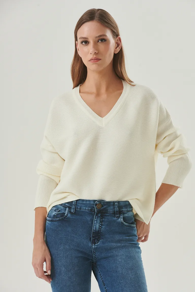 Suéter de punto blanco con escote en V y corte relajado, prenda versátil para looks casuales y urbanos de Sweet en Buzos y Sweaters para argentina