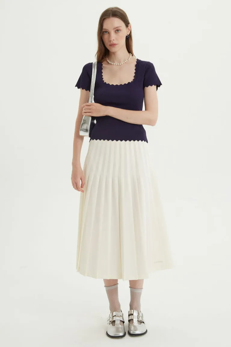 Falda midi plisada de tiro alto con herrajes metálicos en la cintura y corte evasé de Las Pepas en Faldas para argentina