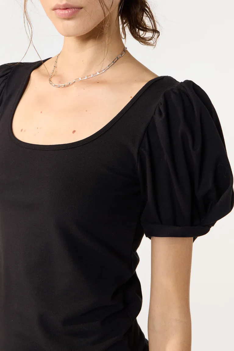 Remera negra con mangas abullonadas y escote en V, prenda versátil para un look casual y elegante de Cuesta Blanca en Remeras para argentina