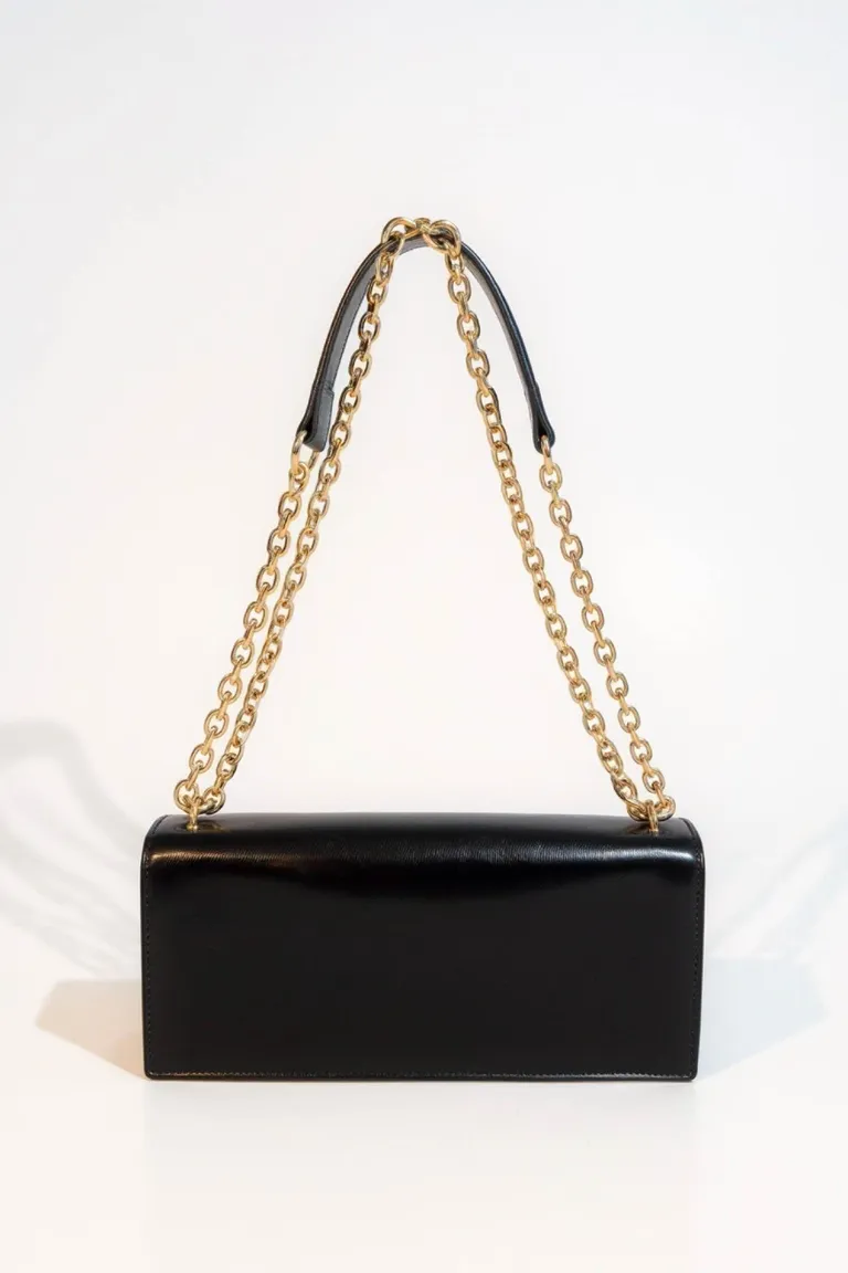 Cartera rectangular con cadena metálica dorada, solapa frontal, broche a presión y compartimento interno con logo aplicado de Maria Cher en Bolsos y Carteras para argentina