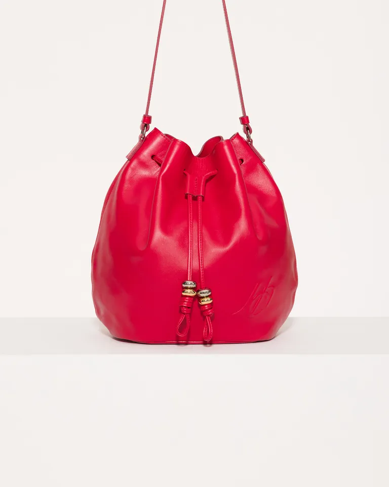 Bolso tipo bucket de gamuza roja con detalles metálicos y cierre interior de Jazmin Chebar en Bolsos y Carteras para argentina