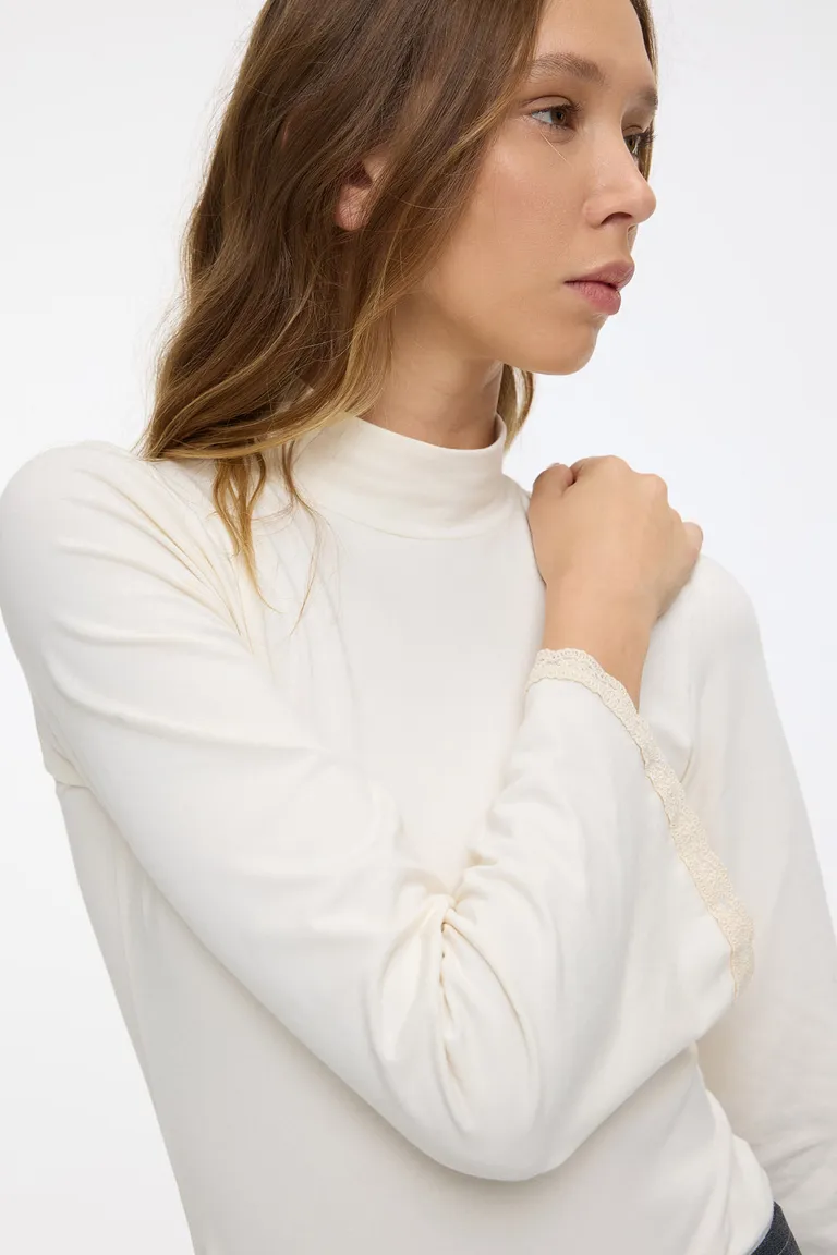 Body de manga larga acampanada con detalles de puntilla y cuello media polera de Cuesta Blanca en Bodies para argentina