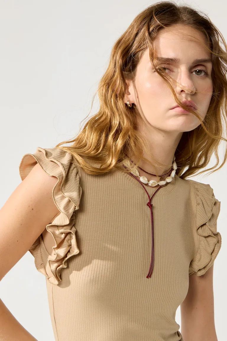 Elegante musculosa beige con volados en sisas y cuello agregado de Cuesta Blanca en Tops para argentina