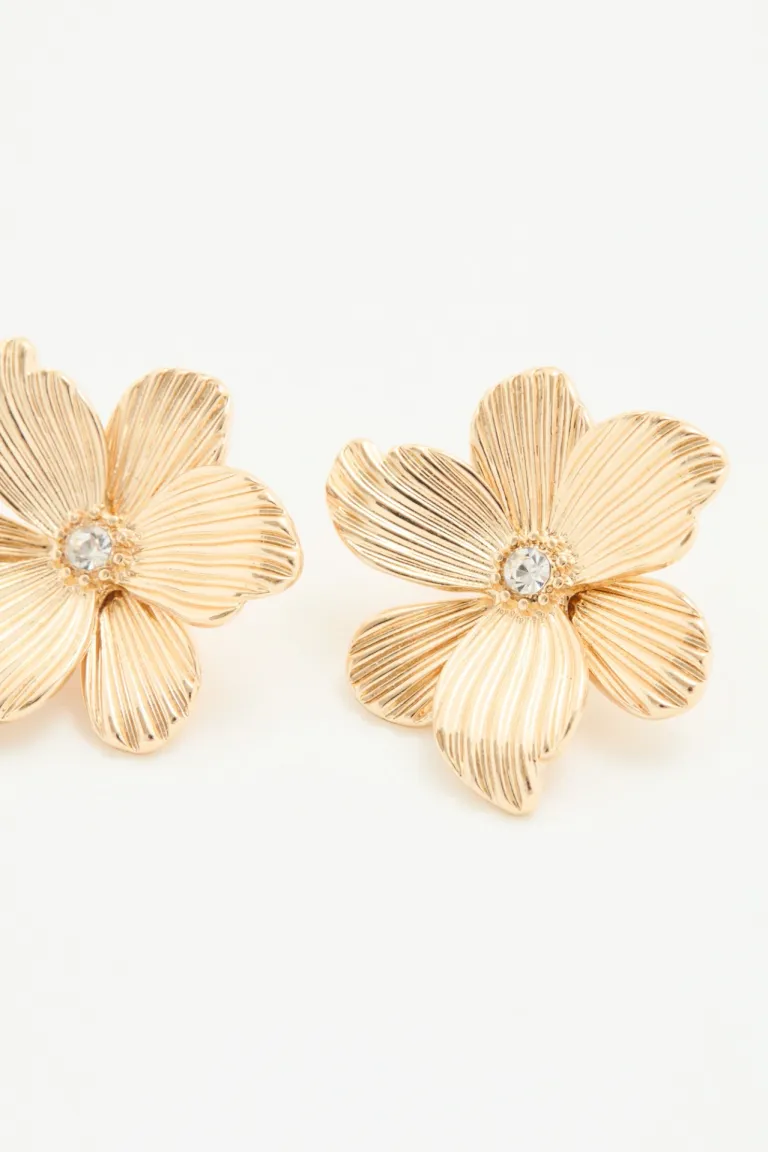 Aros pasantes con forma de flor y centro de strass, color dorado de Rapsodia en Bijouterie para argentina