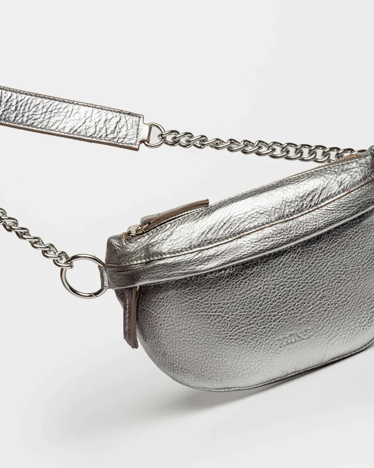 Riñonera de cuero metalizado con manija y cadena - un accesorio trendy y práctico de Prüne en Riñoneras para argentina