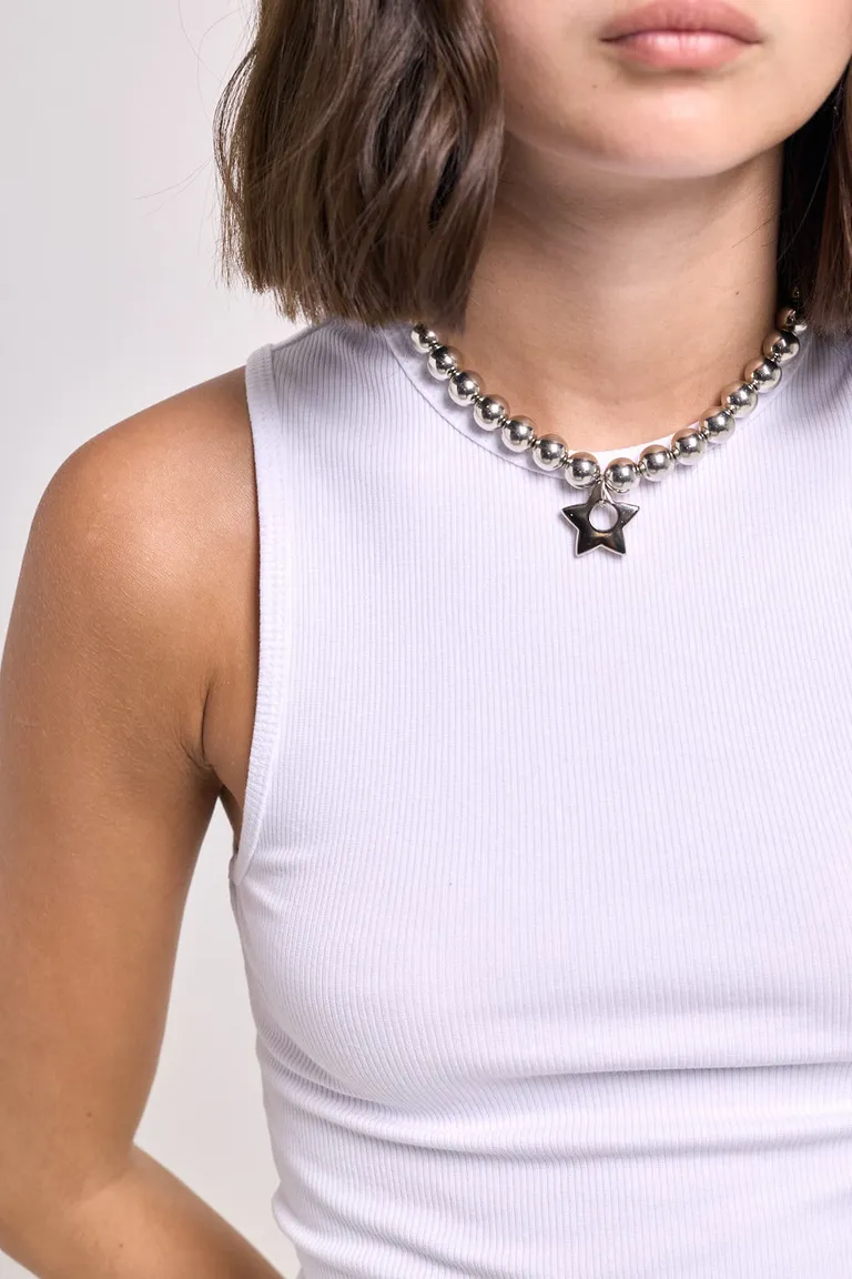 Musculosa básica sin mangas de calce al cuerpo con escote redondo y detalle institucional en el ruedo de 47 Street en Remeras para argentina