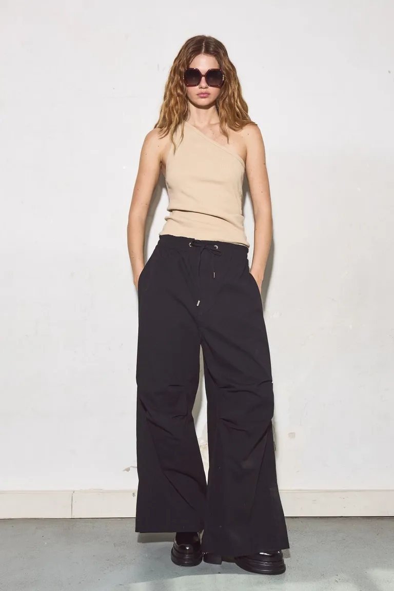 Pantalón negro de diseño tecnológico con morfología diferenciada y cierre con cordón de Allo Martinez en Pantalones para argentina