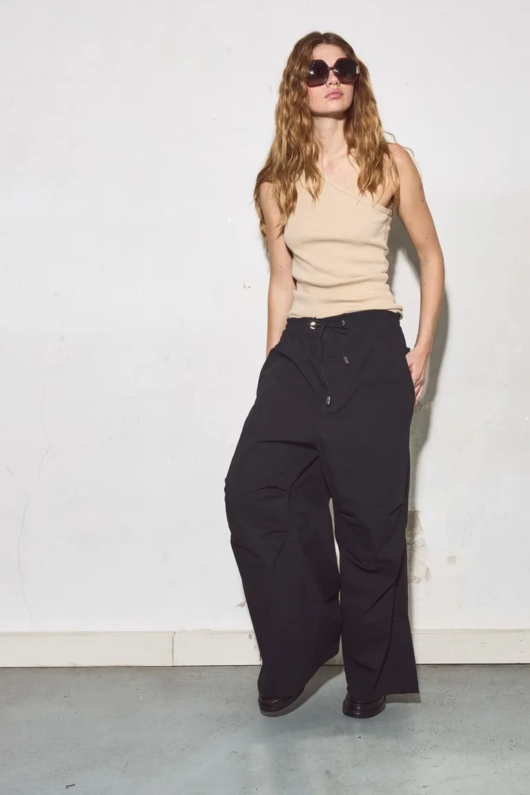 Pantalón negro de diseño tecnológico con morfología diferenciada y cierre con cordón de Allo Martinez en Pantalones para argentina