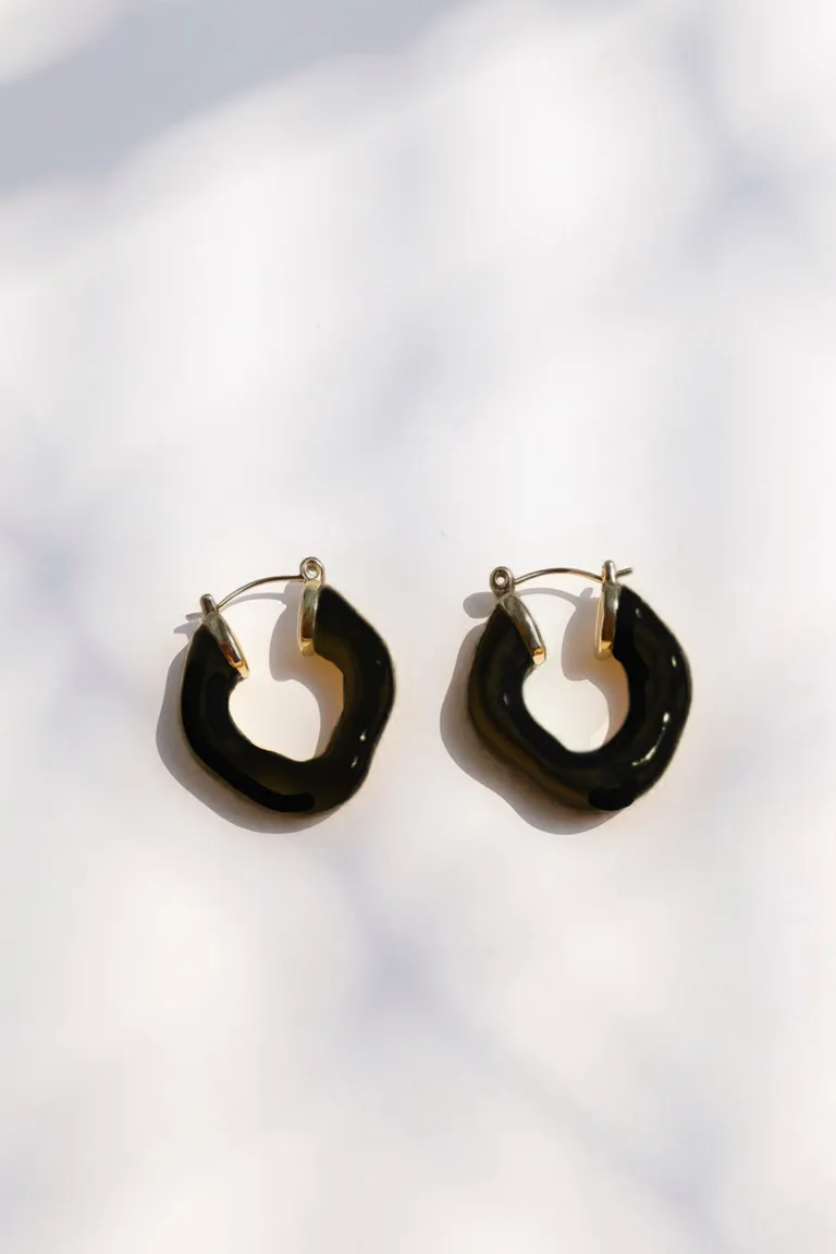 Aros negros de acabado brilloso con forma orgánica y textura lisa de Maria Cher en Bijouterie para argentina