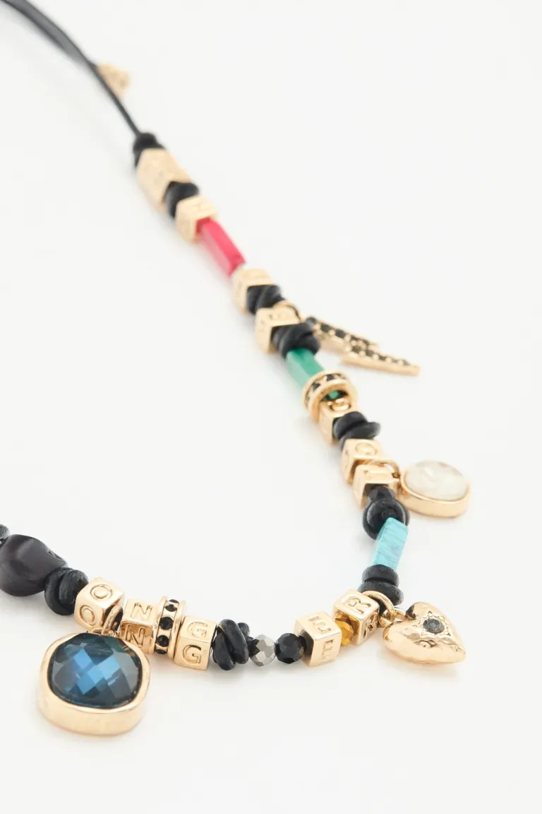 Collar artesanal con cordón ajustable, piedras multicolores y dije de alitas de Rapsodia en Bijouterie para argentina