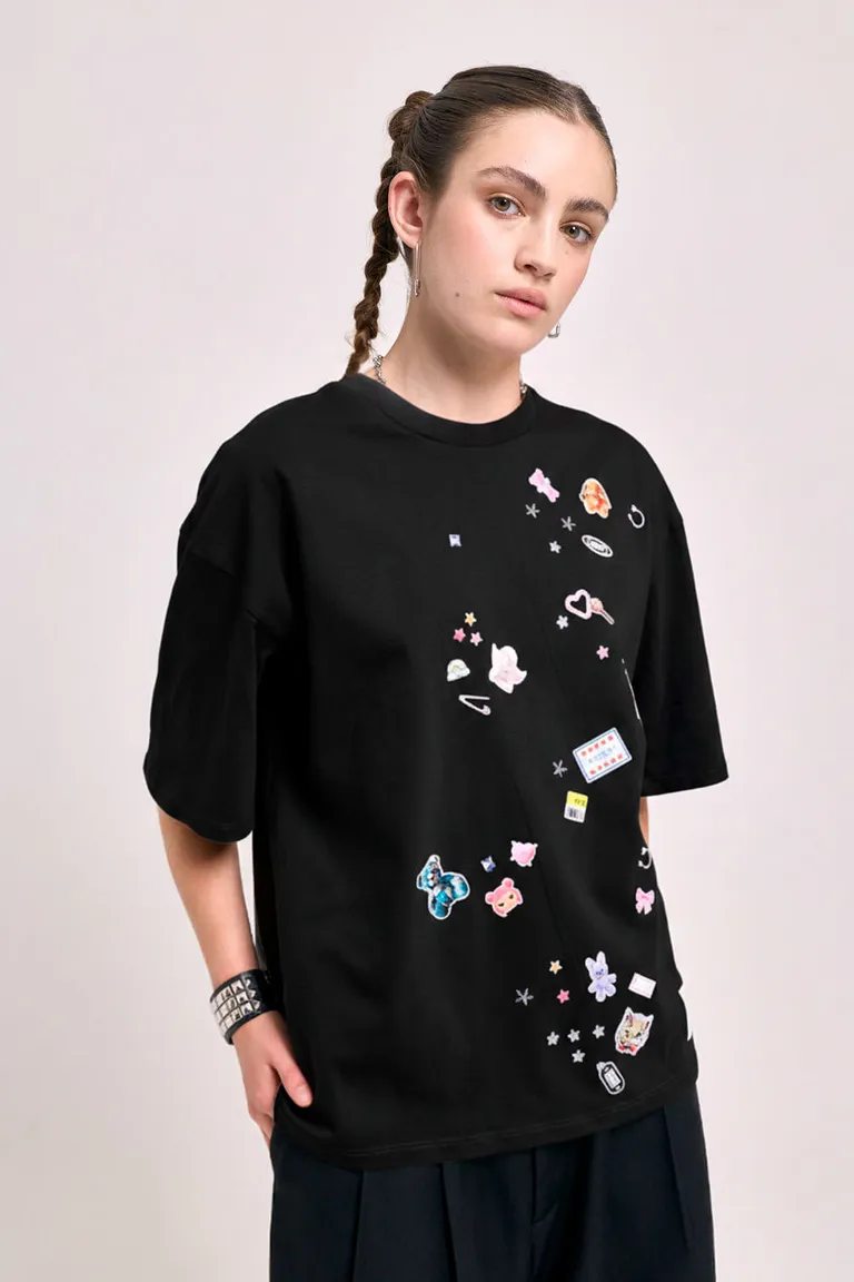 Remera cuello redondo de calce holgado con apliques decorativos tipo stickers dispersos en el frente de 47 Street en Remeras para argentina
