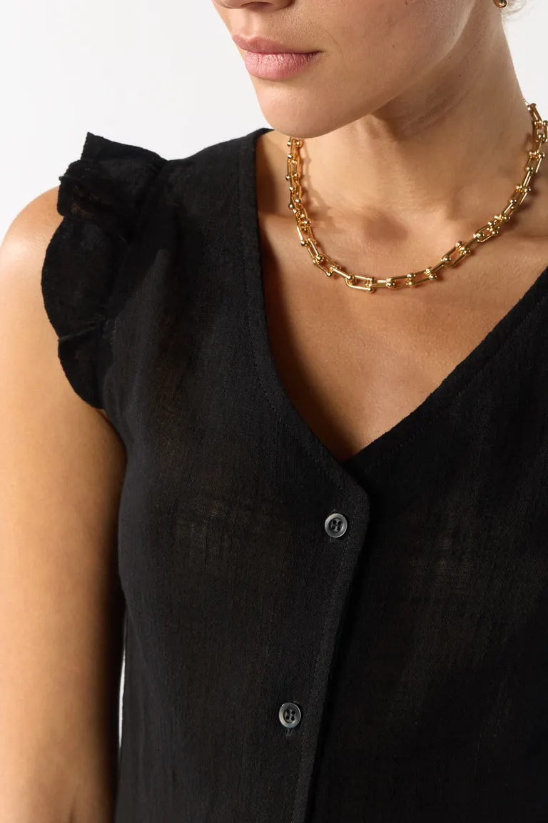 Blusa negra con volados en los hombros, diseño femenino y sofisticado de Cuesta Blanca en Tops para argentina