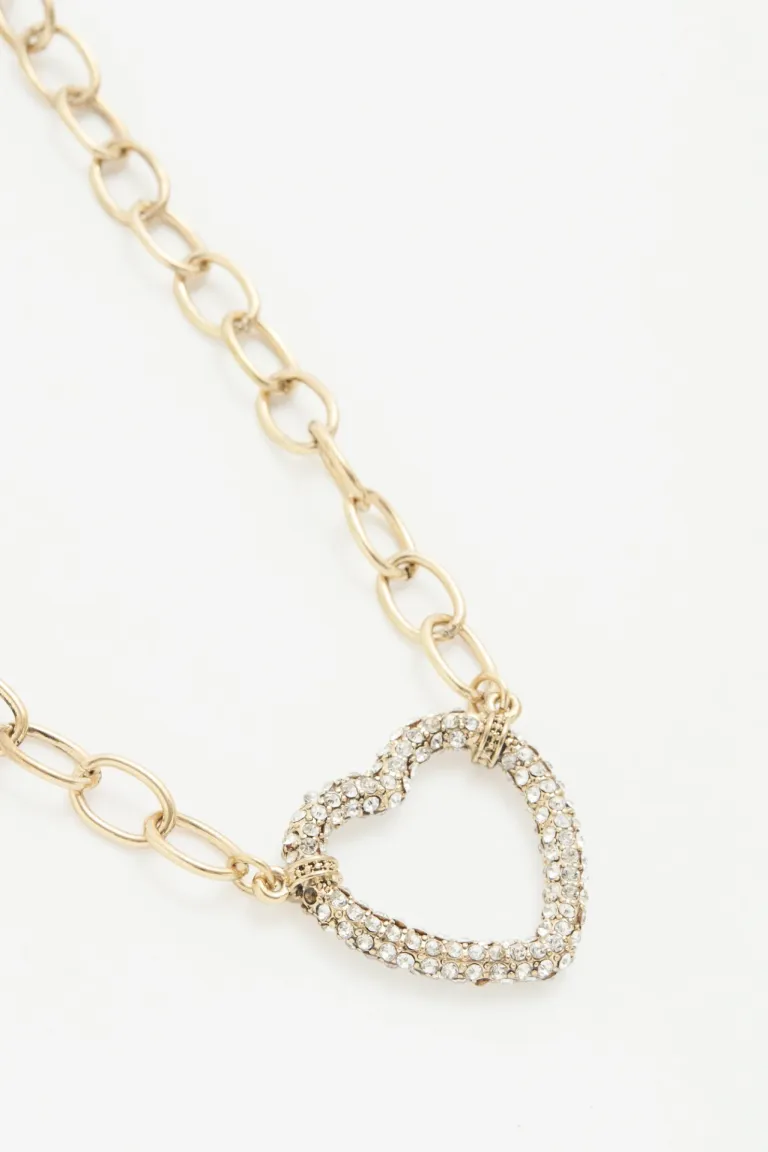 Collar dorado con dije de corazón en strass plateado y cadena de extensión de Rapsodia en Bijouterie para argentina