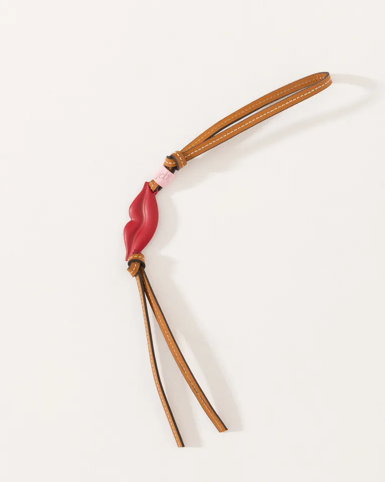 Accesorio colgante de cuero con dije metálico en forma de labios, diseño exclusivo de Jazmin Chebar en Bijouterie para argentina