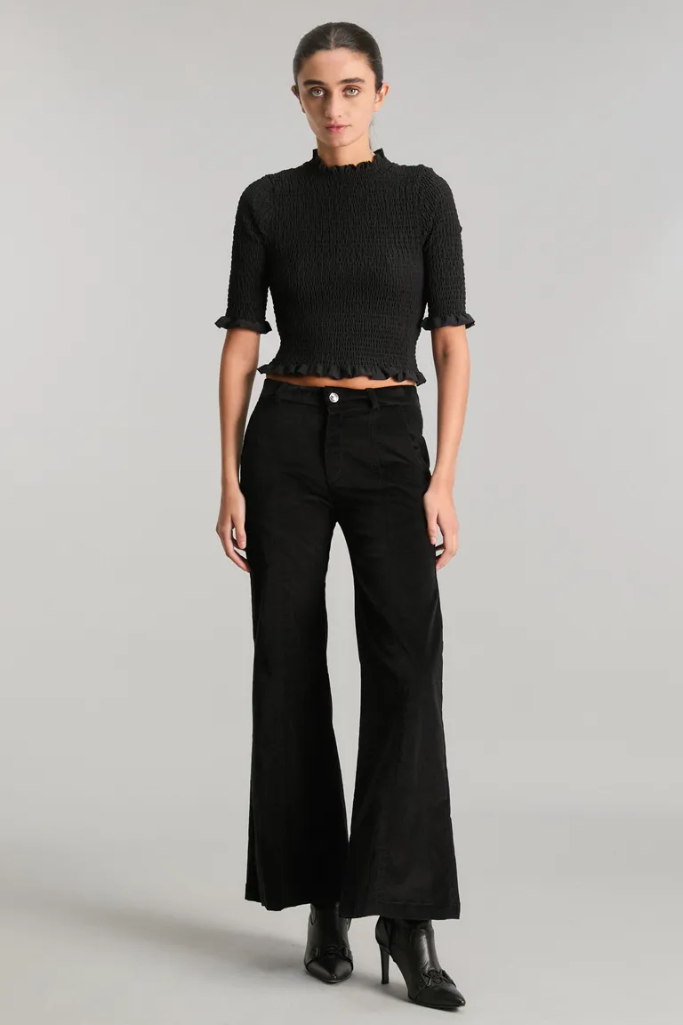 Top negro de diseño minimalista con detalles de volados en cuello, mangas y ruedo de Kosiuko en Tops para argentina