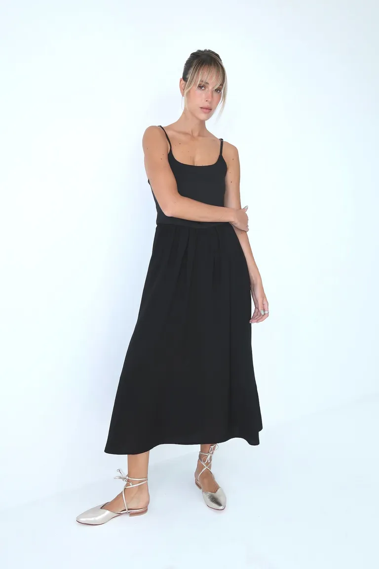 Vestido negro de corte modular y ajuste en la cintura con detalles metálicos de Naíma en Vestidos para argentina