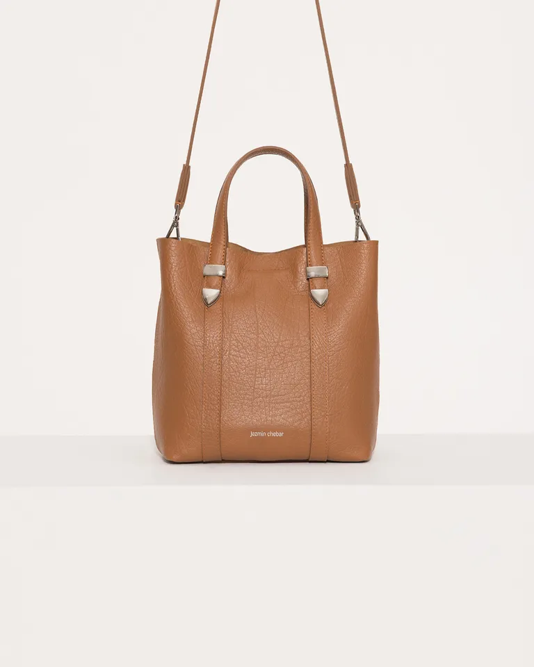 Tote de cuero marrón con detalles metálicos, ideal para el uso diario de Jazmin Chebar en Bolsos y Carteras para argentina