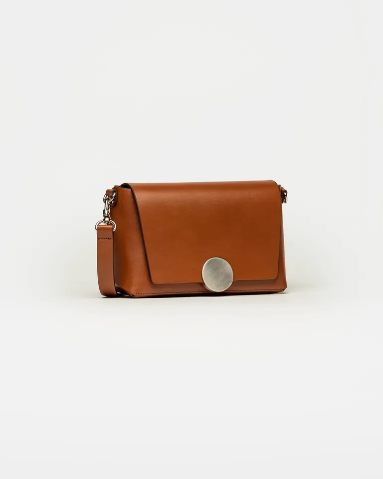 Bandolera pequeña con solapa frontal y detalle de herraje circular metálico central de Prüne en Bolsos y Carteras para argentina