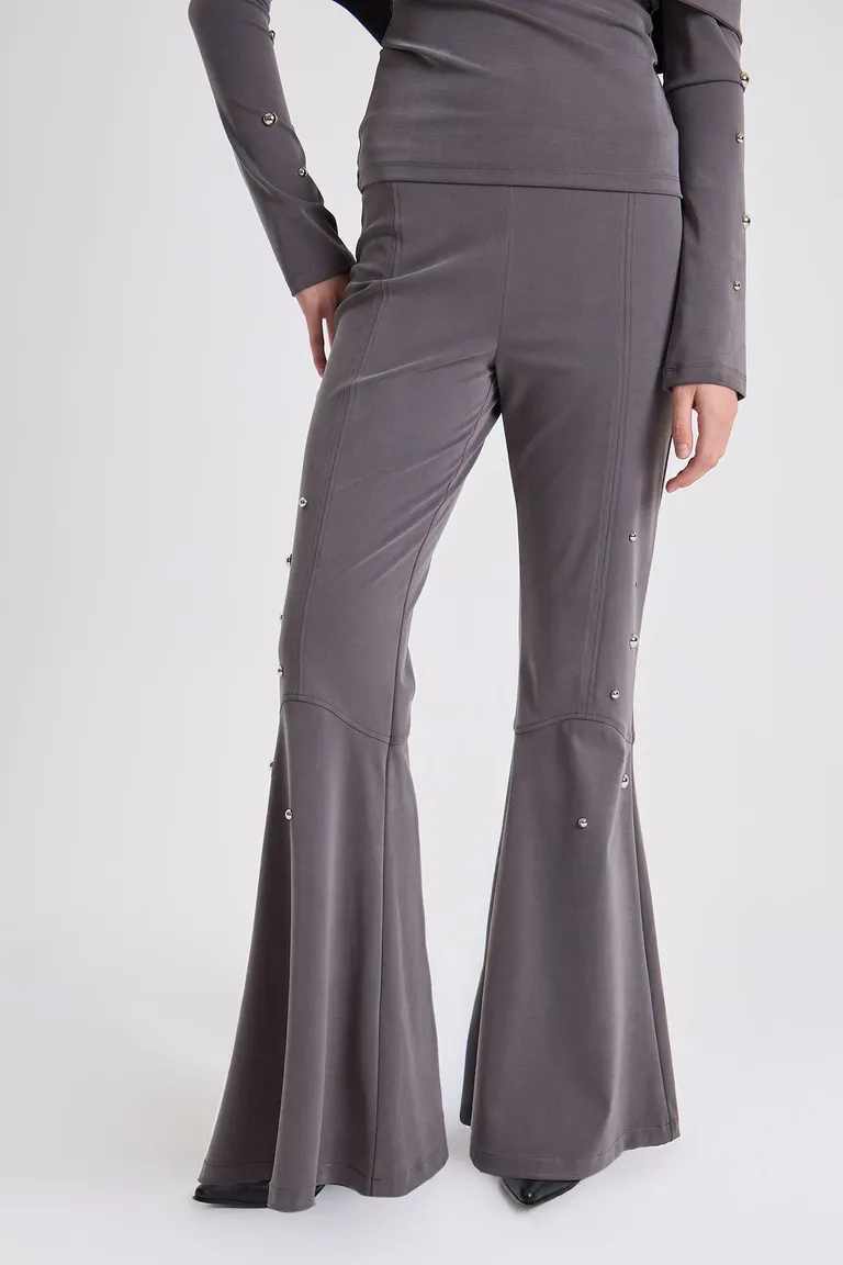 Pantalón largo corte flare con detalle de remaches metálicos decorativos en los costados de Maria Cher en Pantalones para argentina