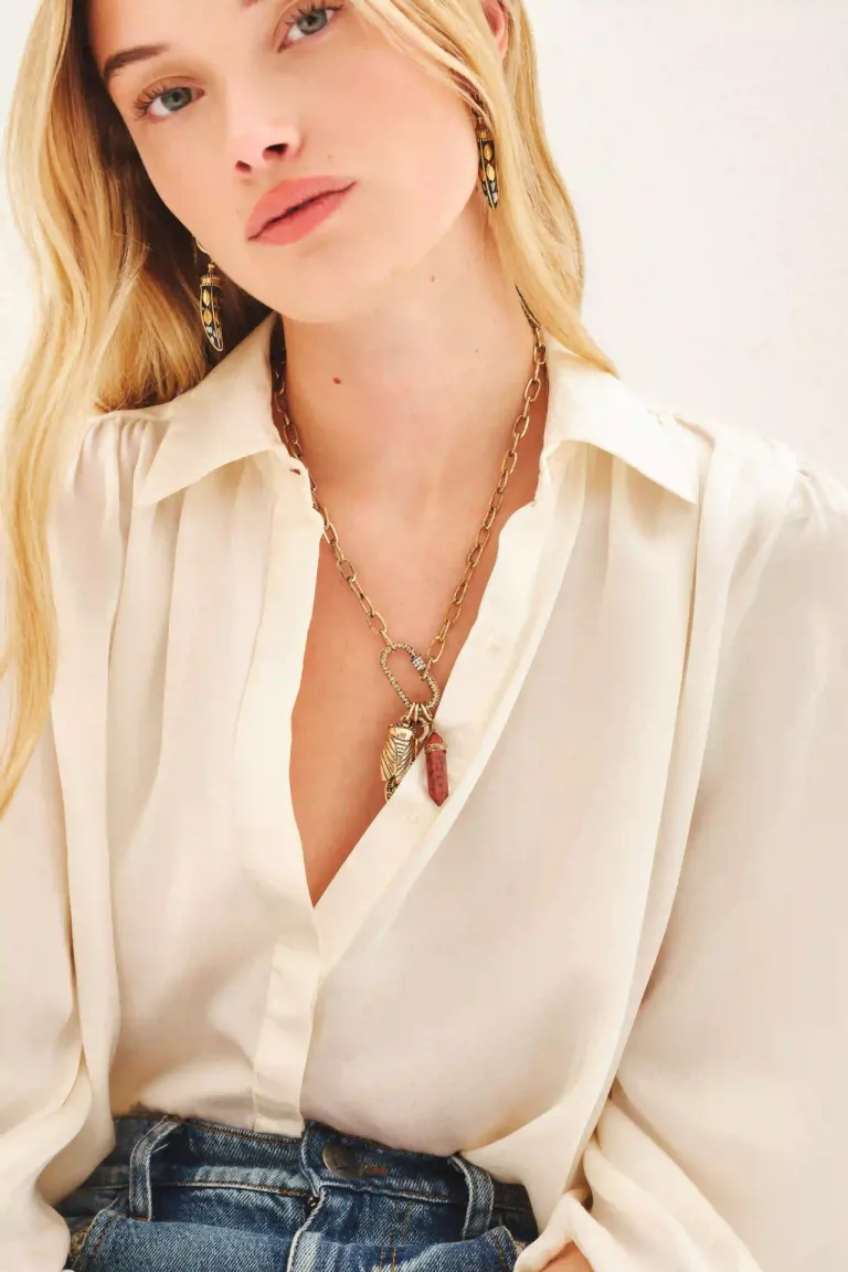 Cadena dorada con dije de piedra roja y detalles en forma de insecto y moneda de Rapsodia en Bijouterie para argentina