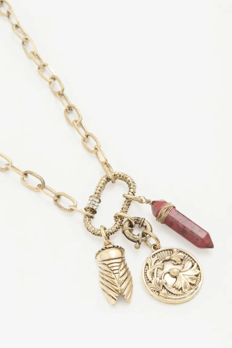 Cadena dorada con dije de piedra roja y detalles en forma de insecto y moneda de Rapsodia en Bijouterie para argentina