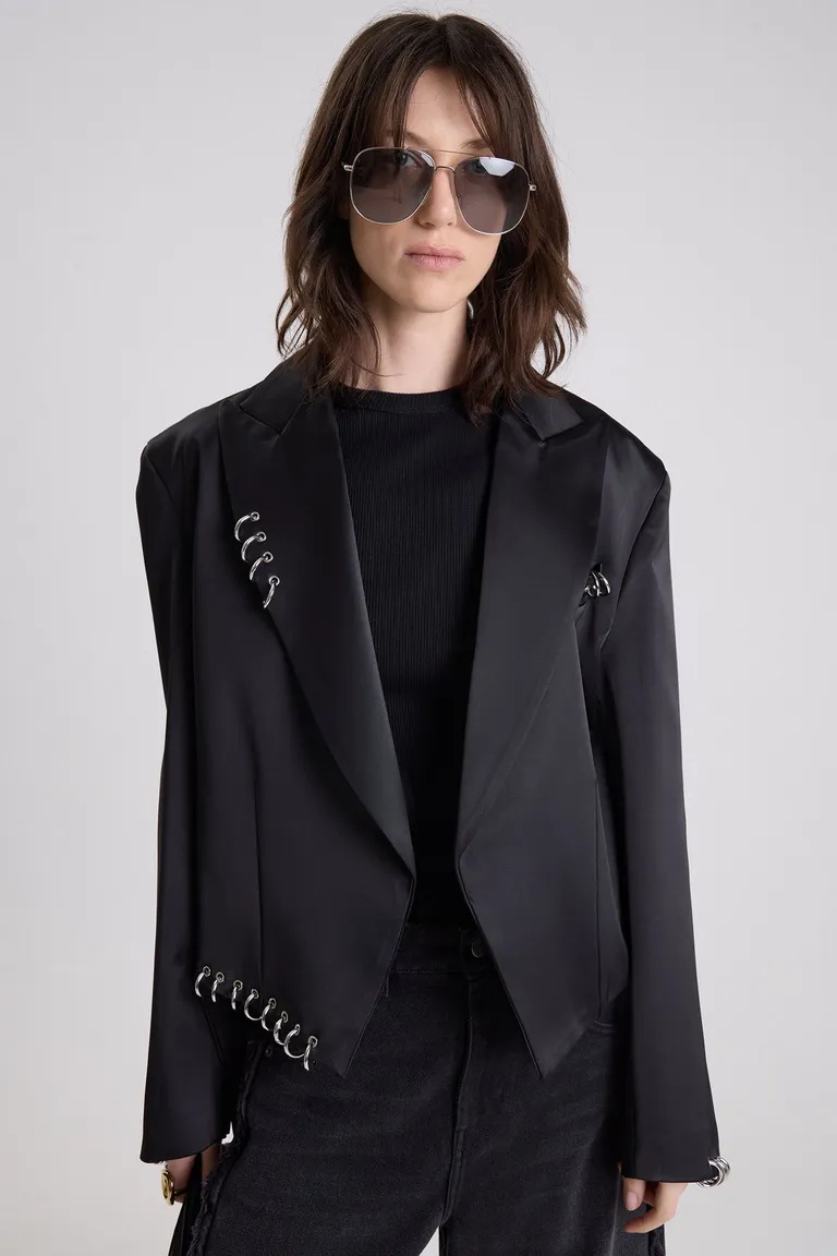 Saco corto sastrero con detalles metálicos de argollas y ojalillos, diseño entallado con solapas clásicas de Maria Cher en Blazers para argentina