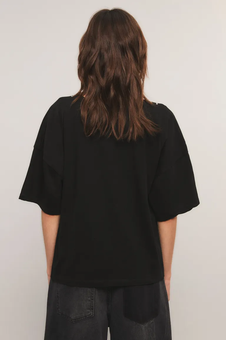 Remera de corte holgado con estampa frontal de cadenas y dijes, cuello redondo y mangas cortas de Kosiuko en Remeras para argentina