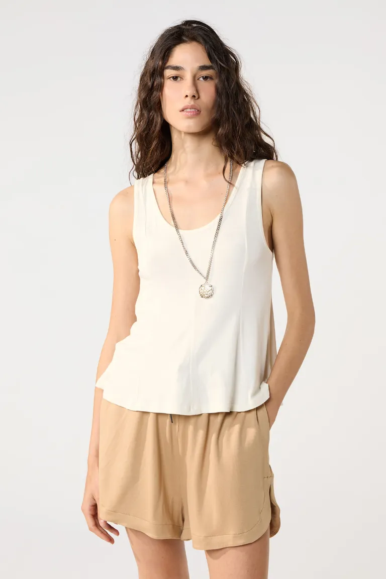 Musculosa blanca de crepe viscosa con detalles en recortes y cintura entallada de Cuesta Blanca en Tops para argentina